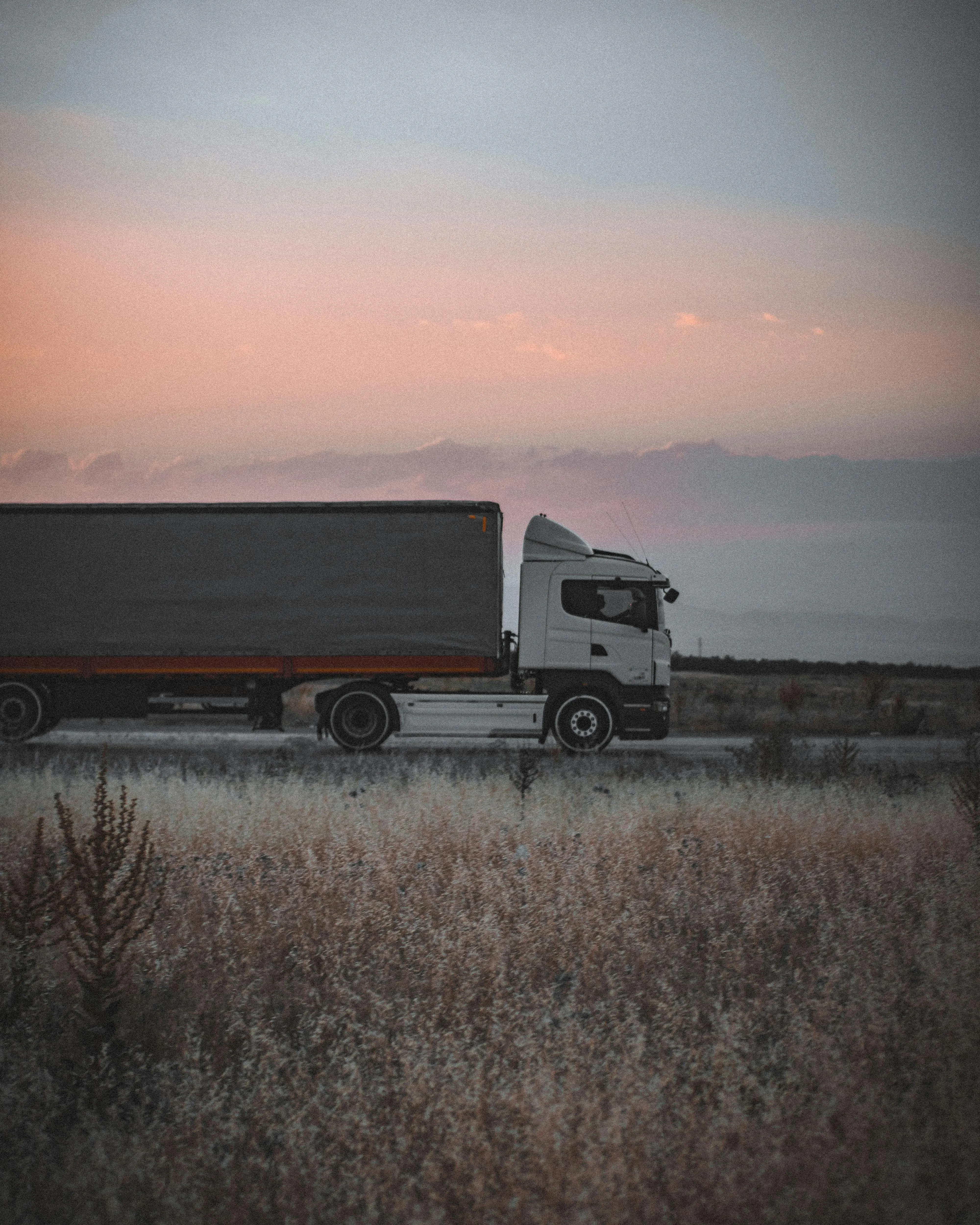 Commercial truck on highway at sunset