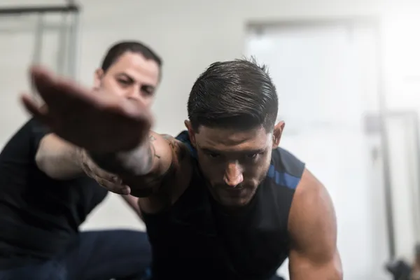 Terapeuta físico guiando al paciente en ejercicios de rehabilitación