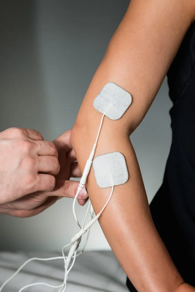 Close-up of TENS therapy device in use